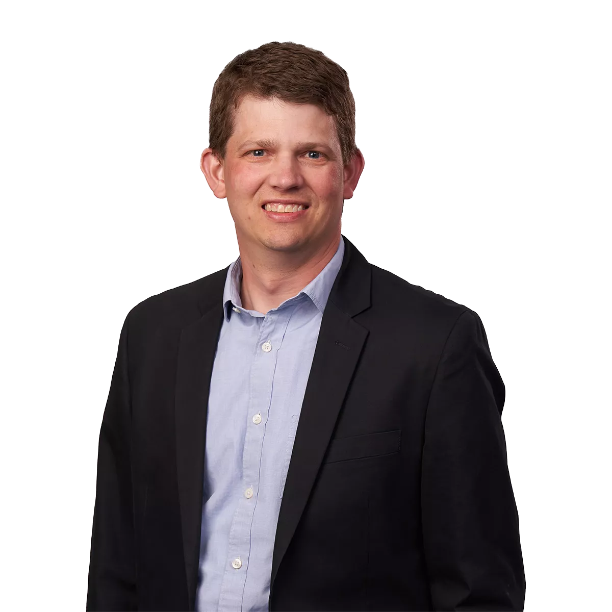 man in a dark suit and light blue shirt smiling at the camera against a plain white background.