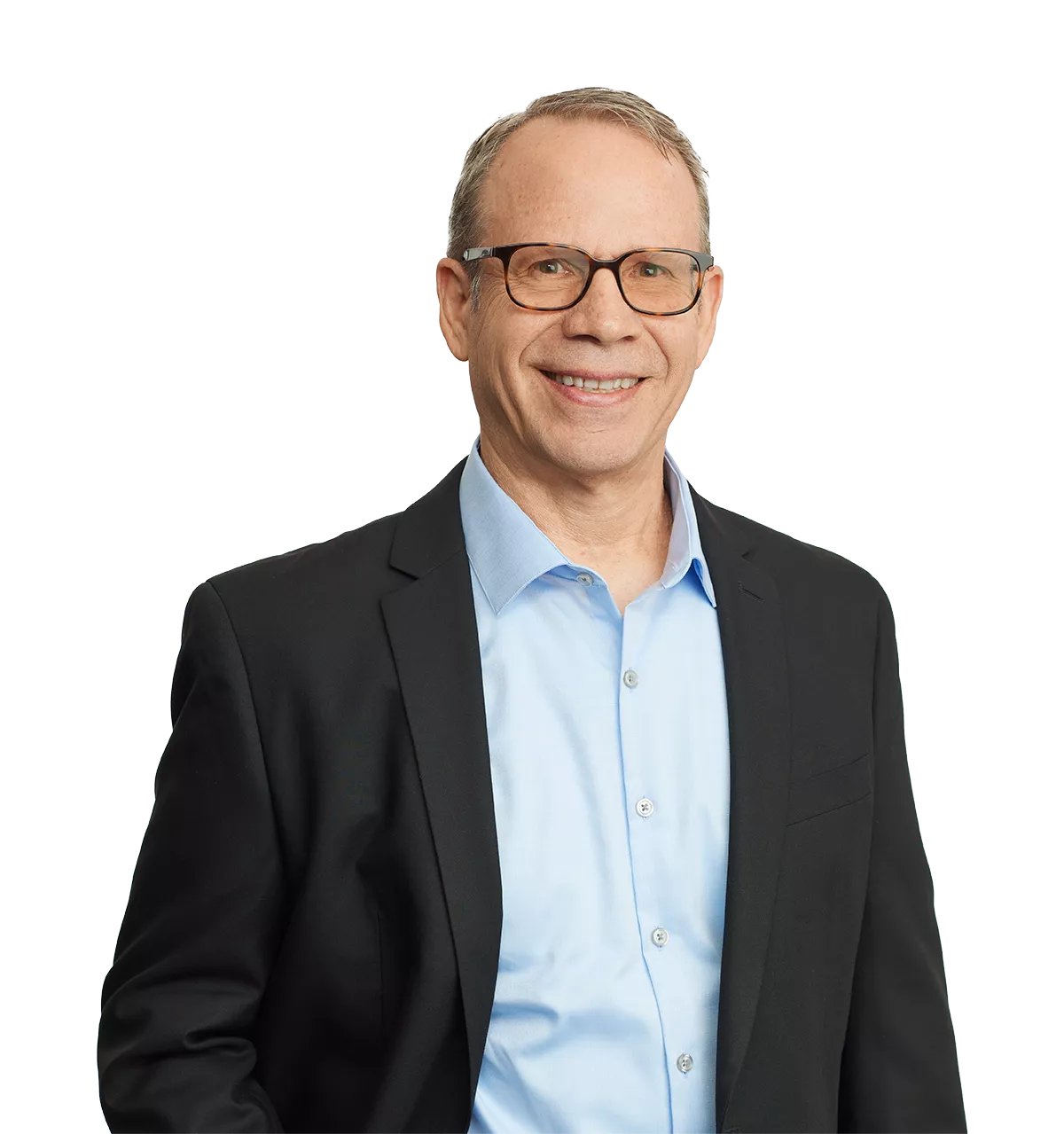 smiling man in glasses and a suit jacket over a light blue shirt, standing against a plain white background.