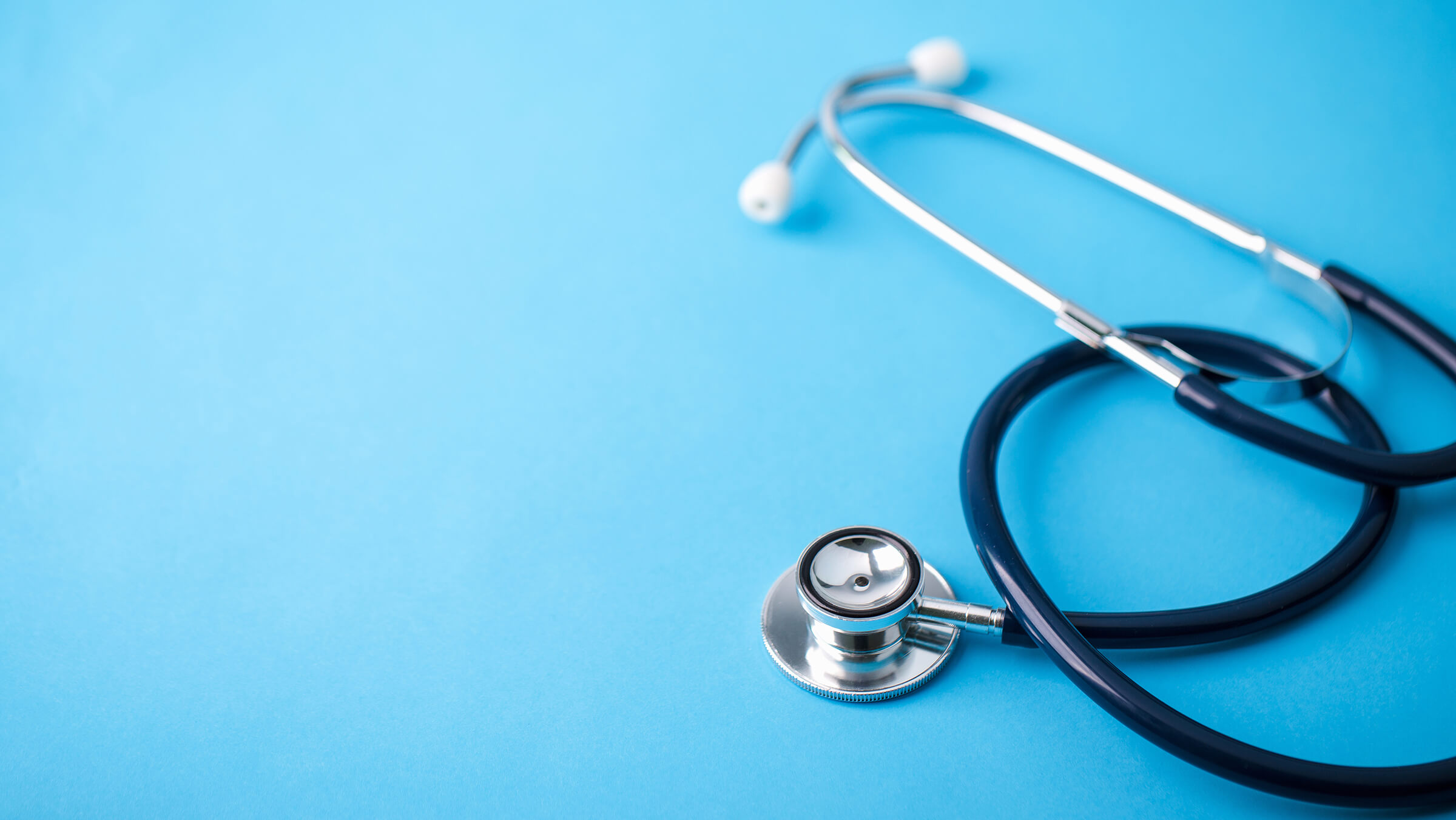 close up of a stethoscope laying on a blue surface