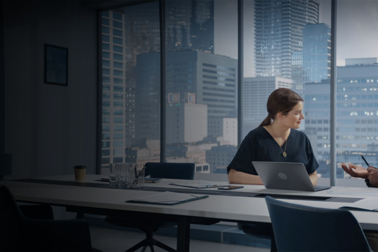 Two business professionals discussing energy market strategy in a city-view conference room