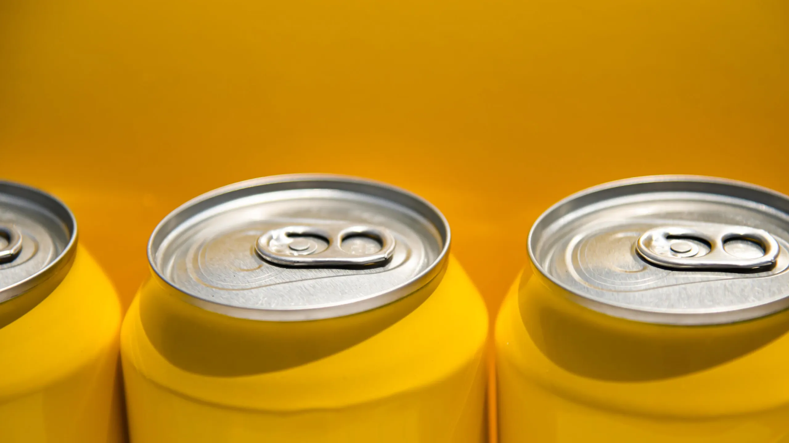 close up of yellow carbonated drink cans