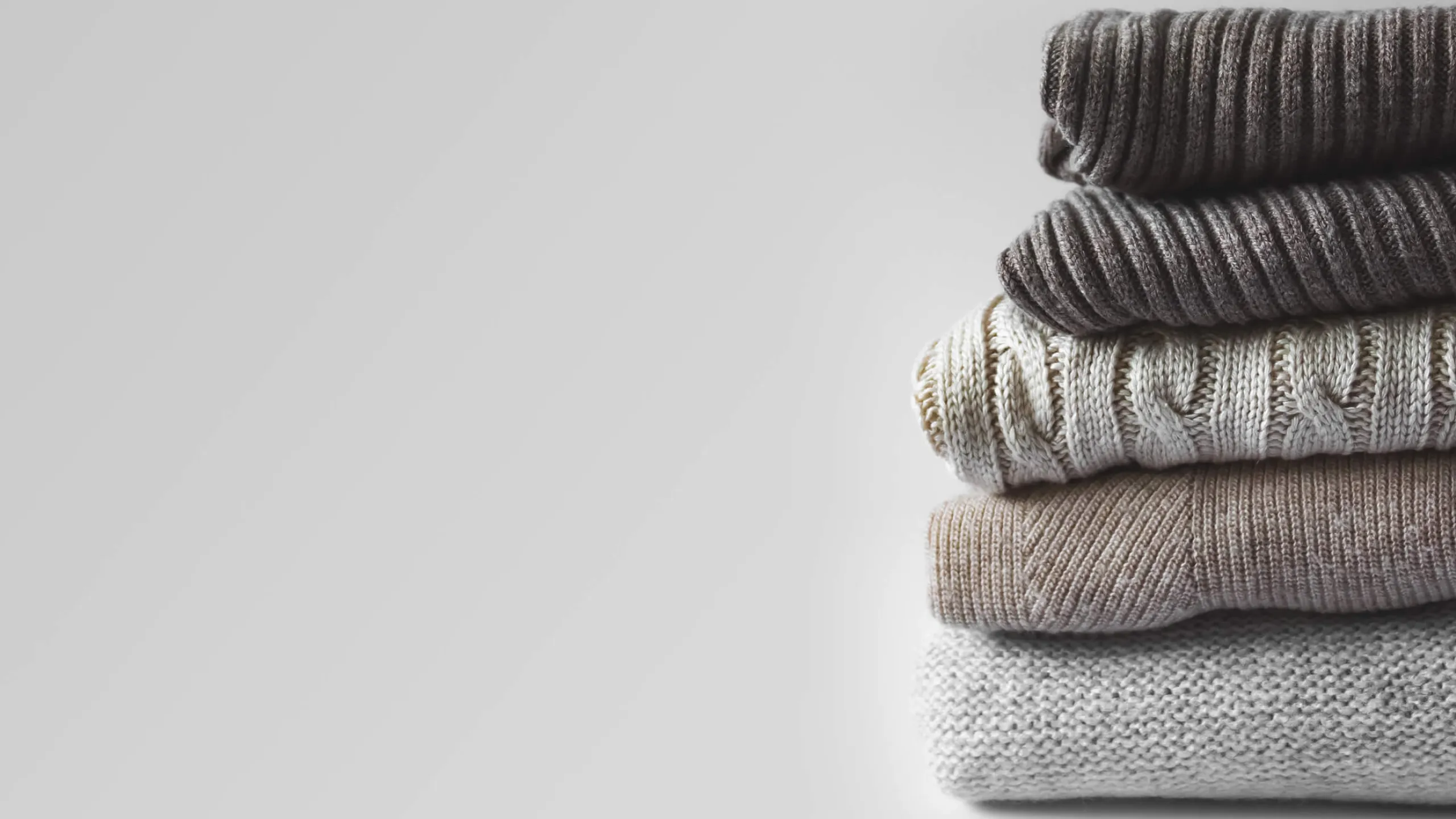 A stack of three knitted sweaters