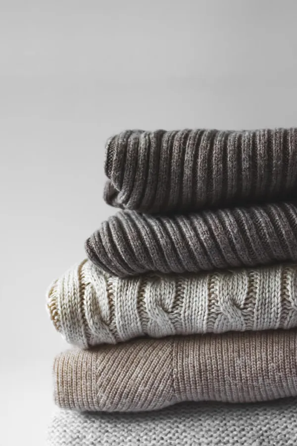 A stack of three knitted sweaters