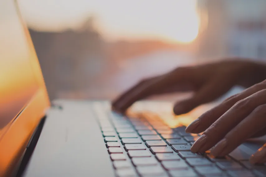 close-up-of-laptop-keyboard-with-hands-paused-over-keys