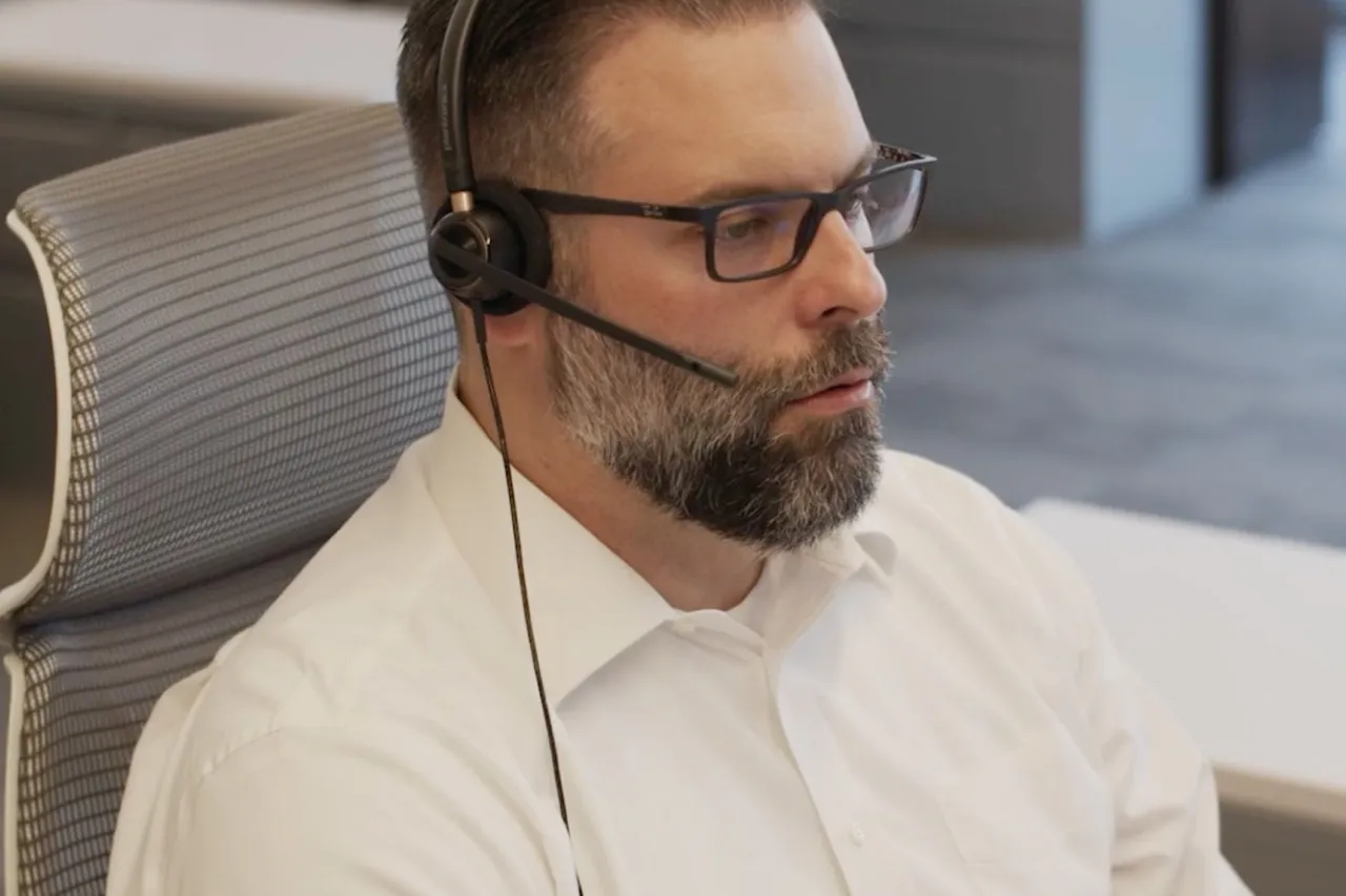 male-employee-sitting-at-desk-with-headset-talent-career