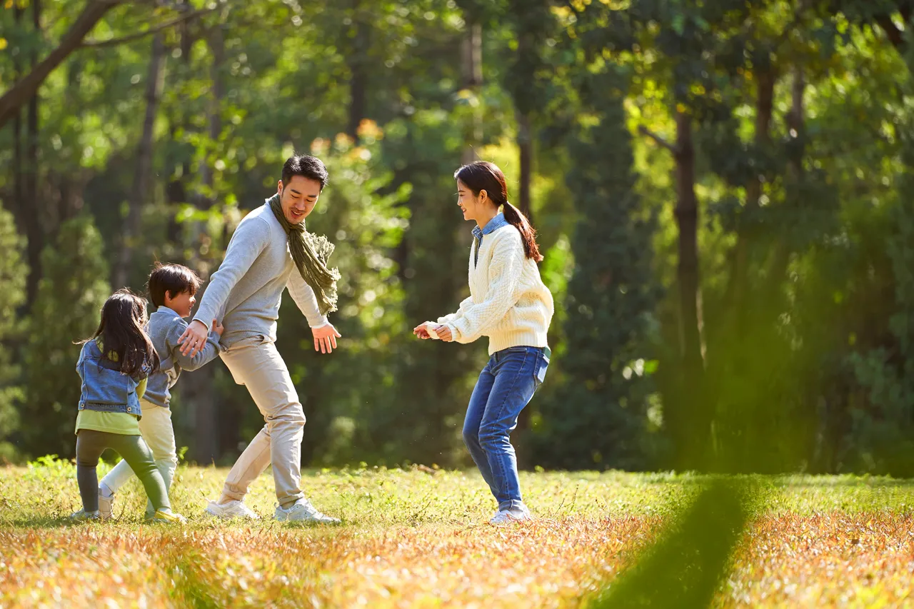 family playing together in a park.