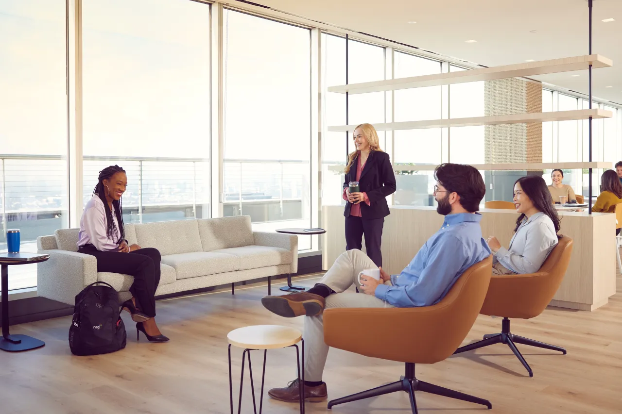 group of coworkers having casual converstaion in office common area.