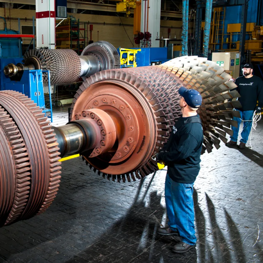 employee inspecting turbine blades components.