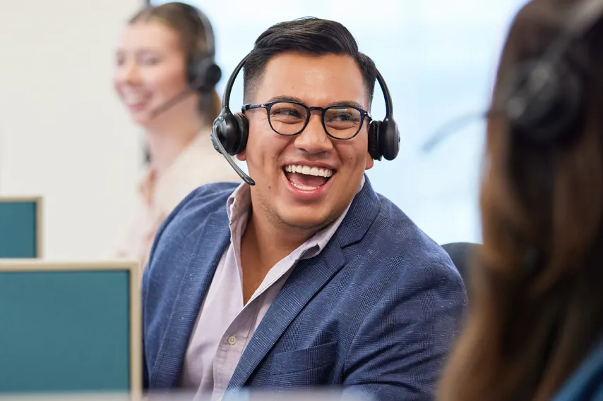 passionate employees smile while wearing headset.