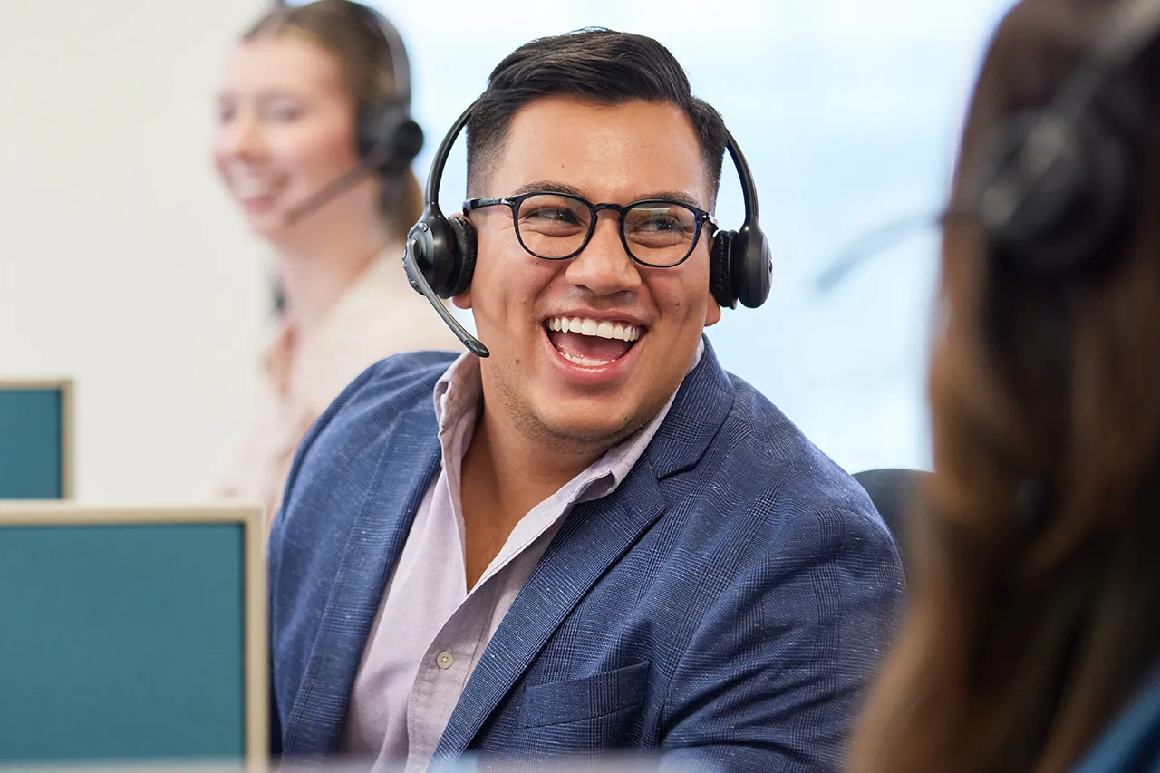 passionate employees smile while wearing headset.