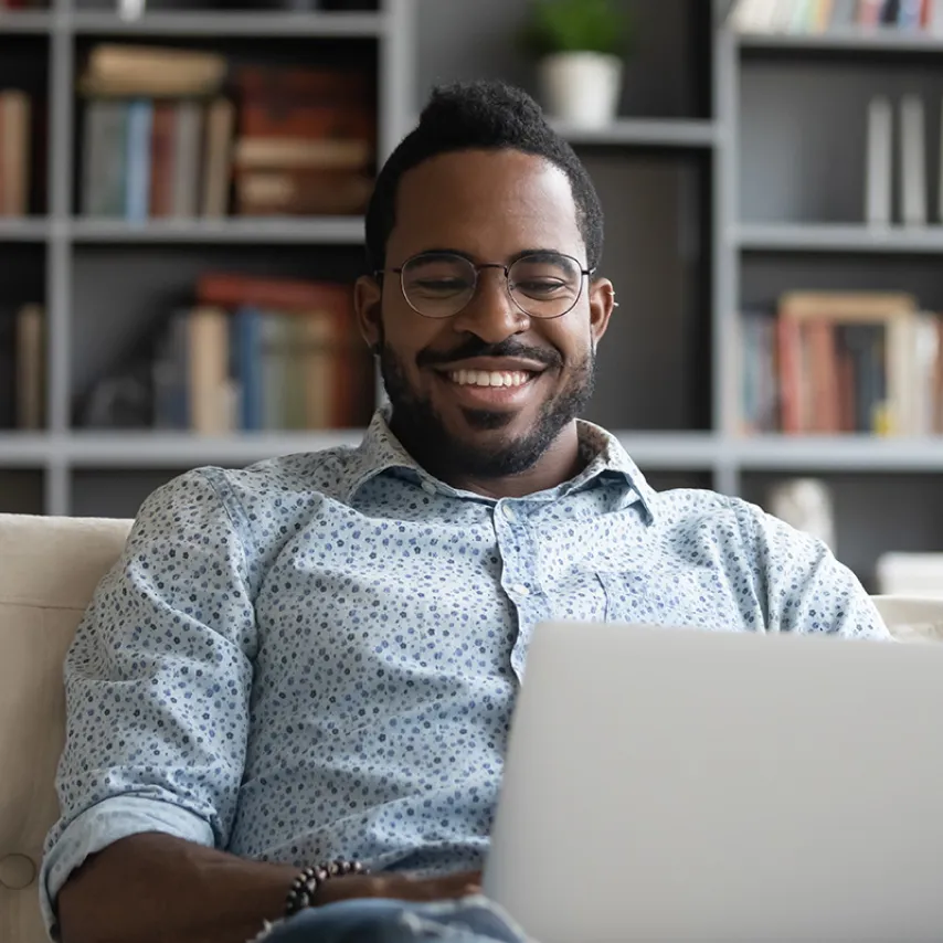 man sitting at laptop smiling.