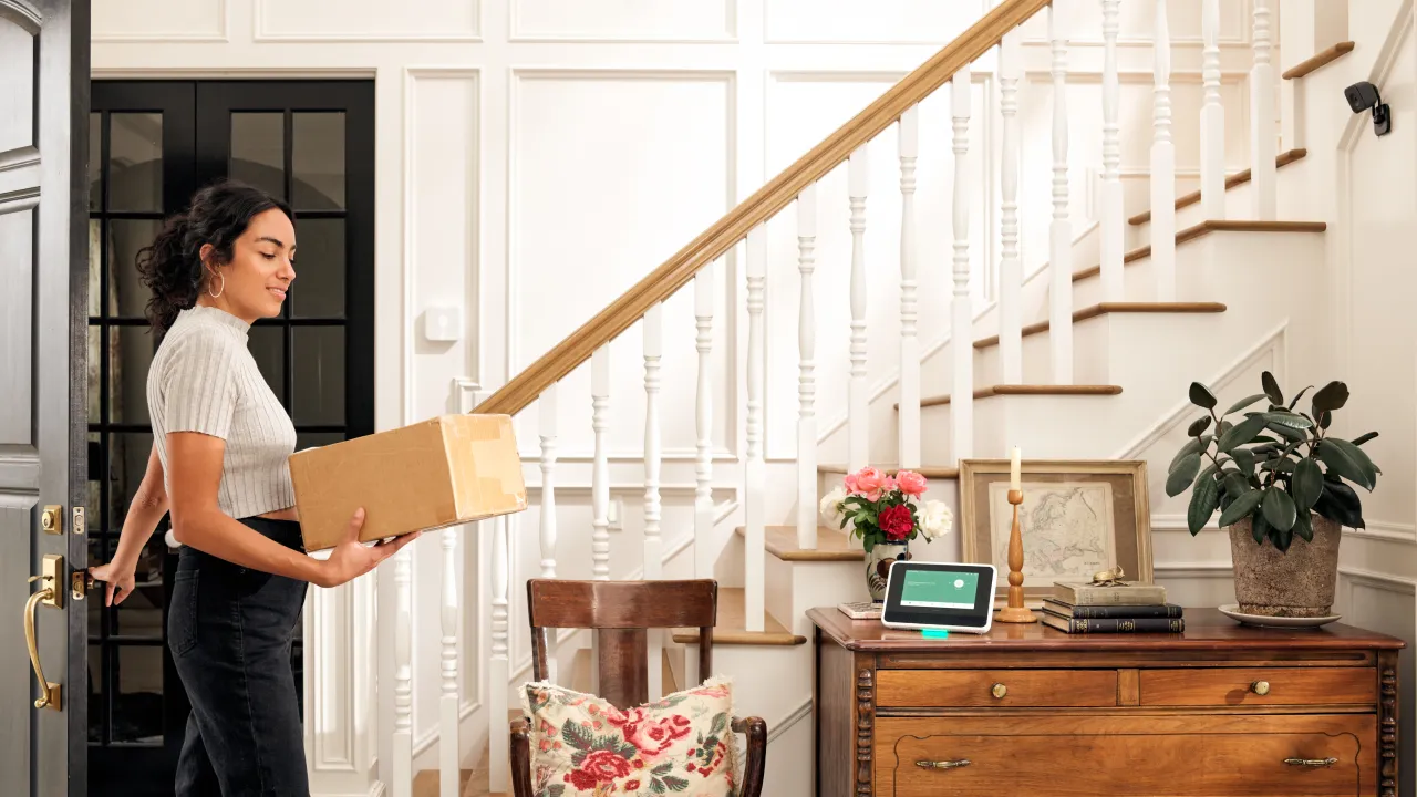 woman-bringing-delivery-package-in-door-vivint-smart-hub