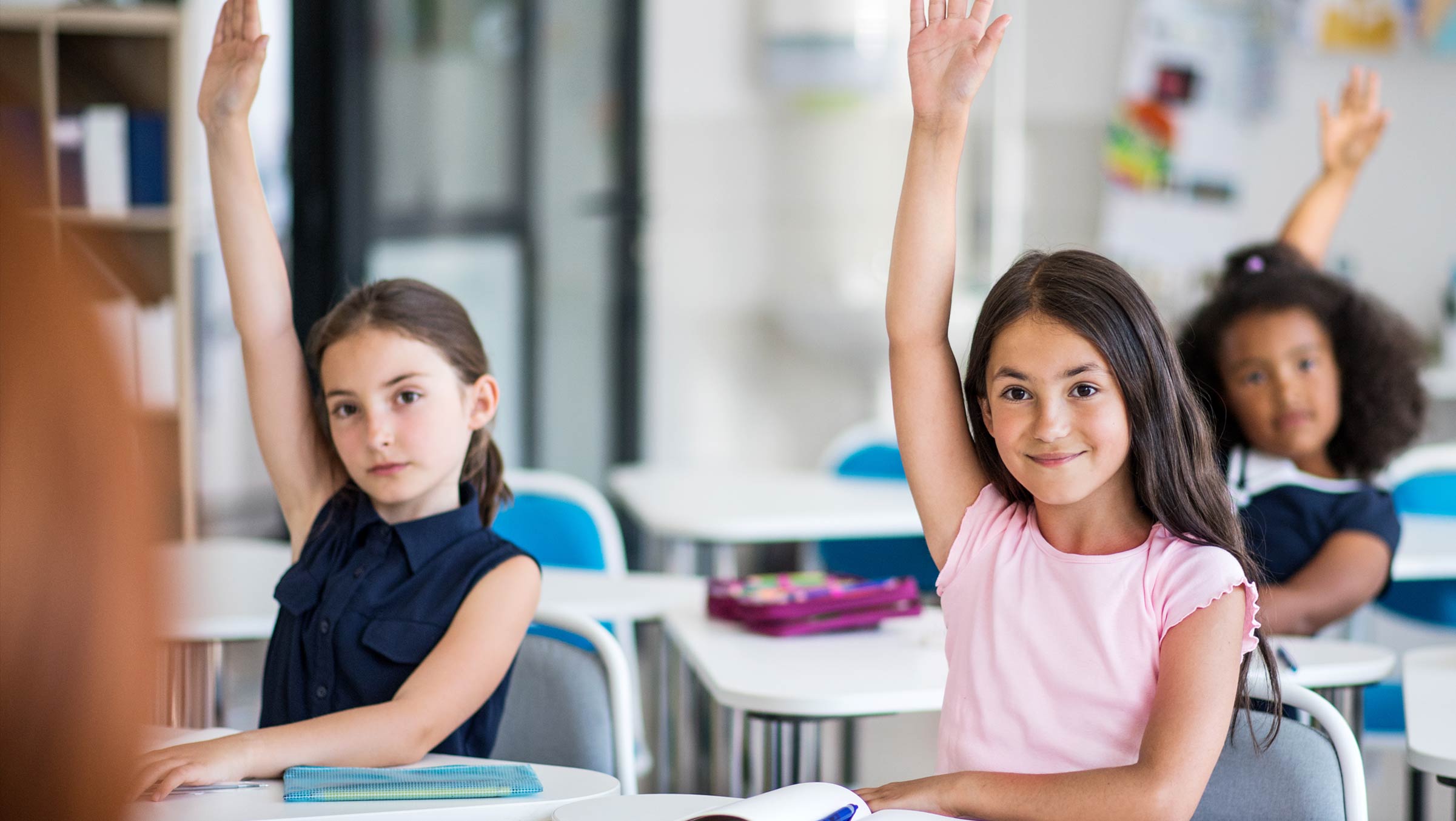 children-in-class-raising-hands