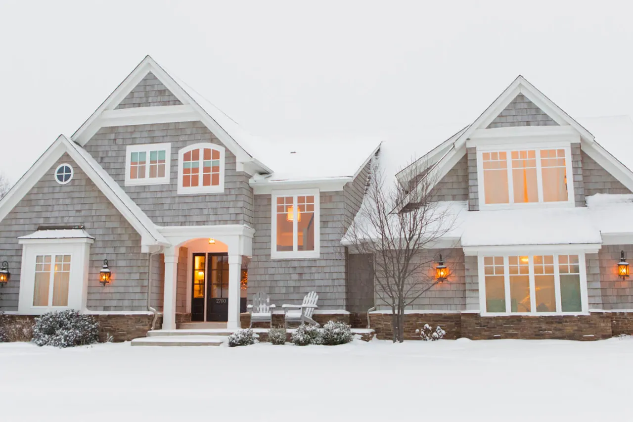 home front in snowy yard with warm lighting.