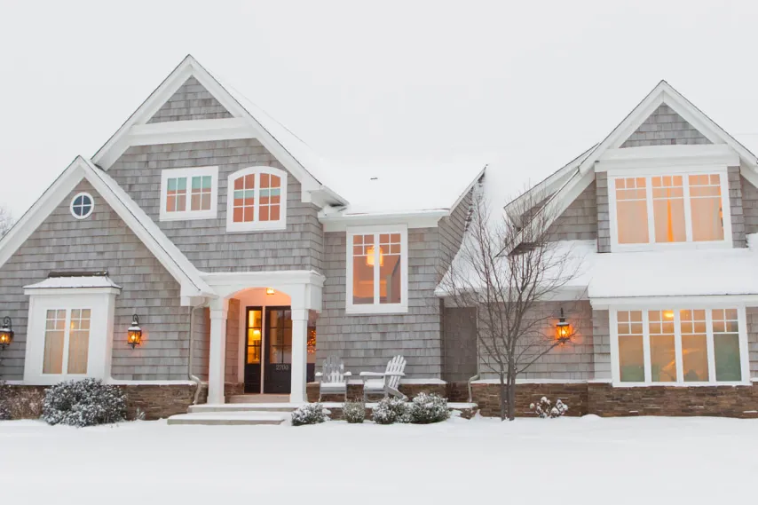 home front in snowy yard with warm lighting.