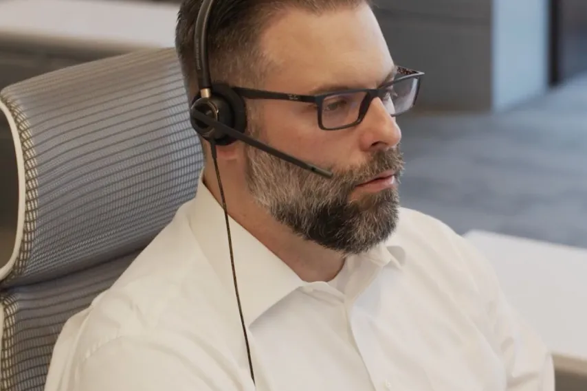 male employee sitting at desk with headset talent career.