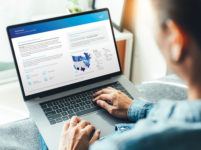 person using a laptop, viewing a website with text, icons, and a blue-and-white map of North America.