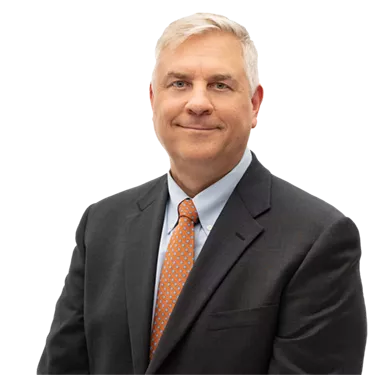 Matt Pistner in a dark suit and orange tie smiles at the camera against a plain white background.
