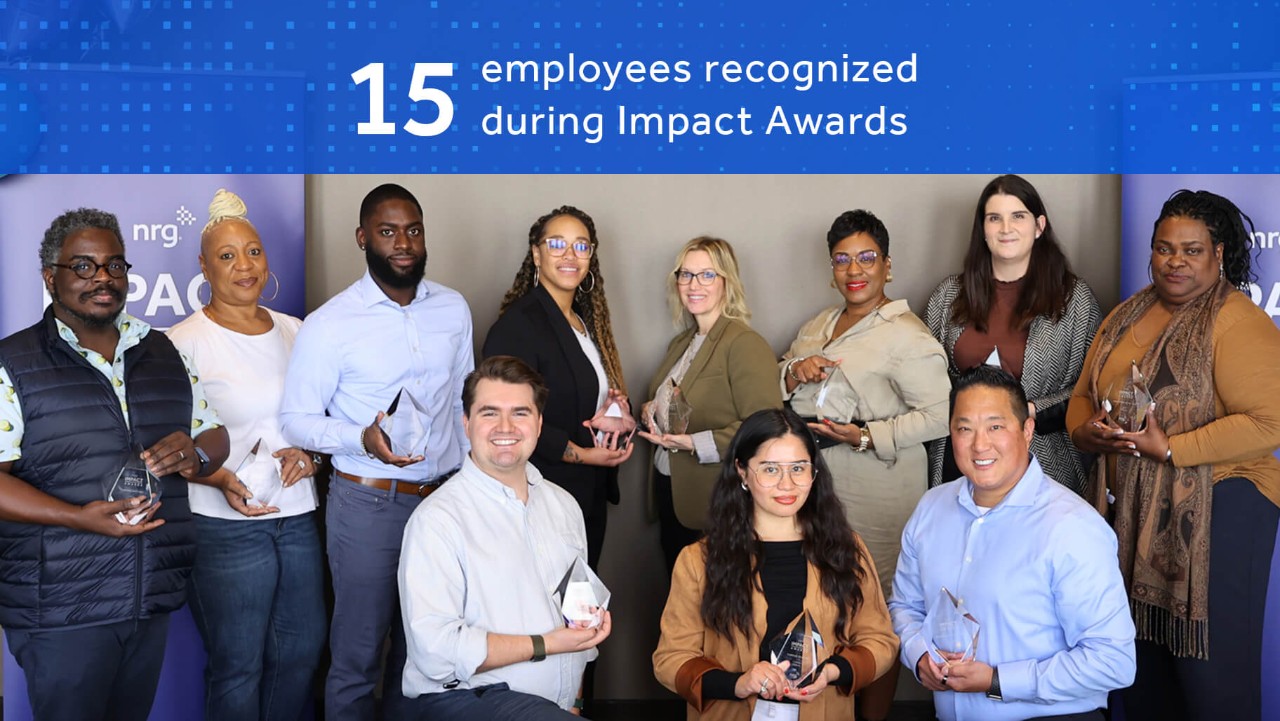 fifteen people pose holding awards under a banner reading 15 employees recognized during Impact Awards..