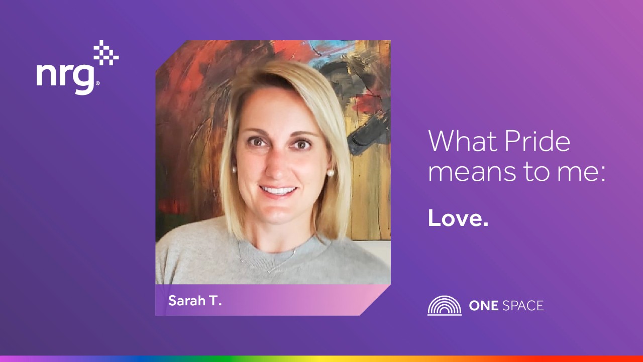 a woman smiles in front of art with the text: What Pride means to me: Love. and NRG. ONE SPACE.