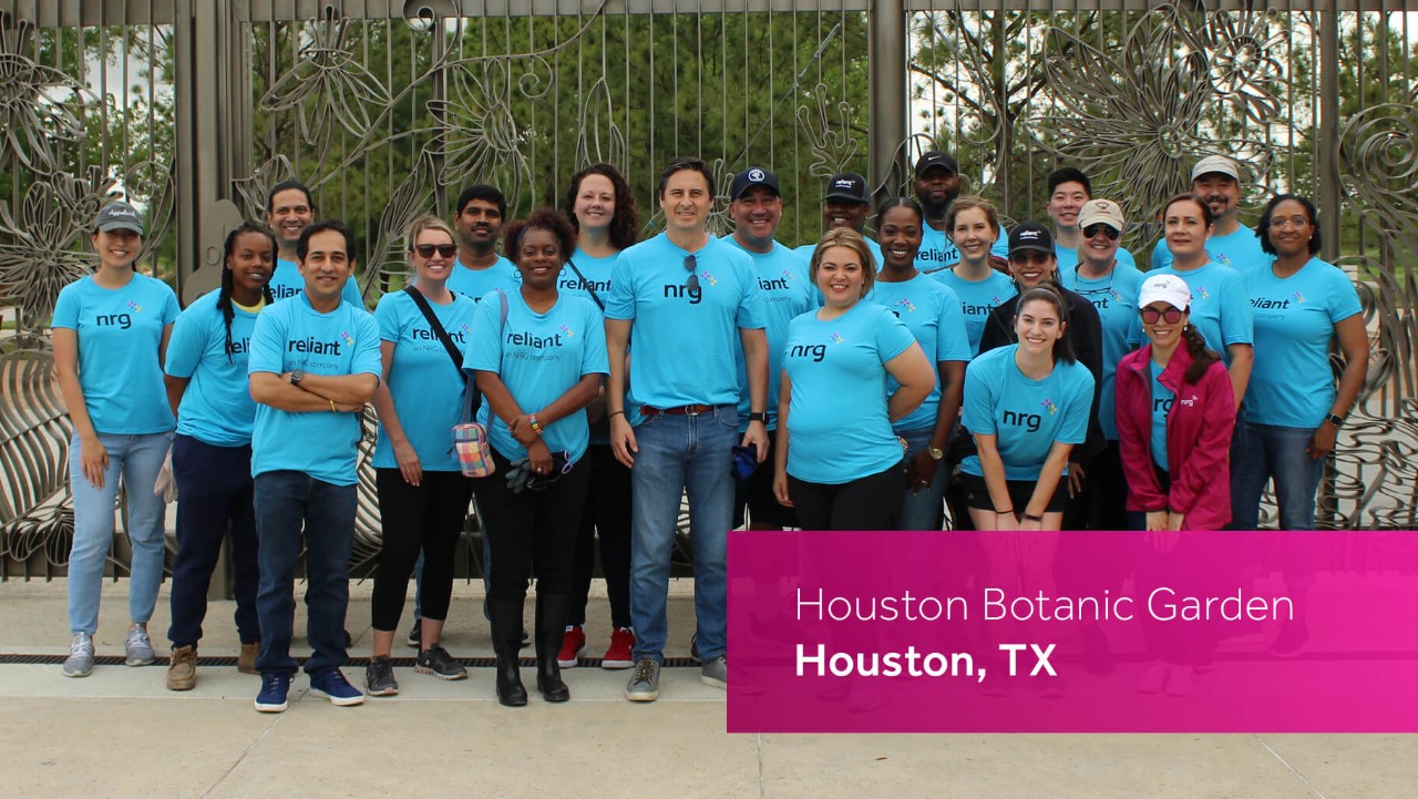 group of people in blue shirts posing outdoors at Houston Botanic Garden, Houston, TX.