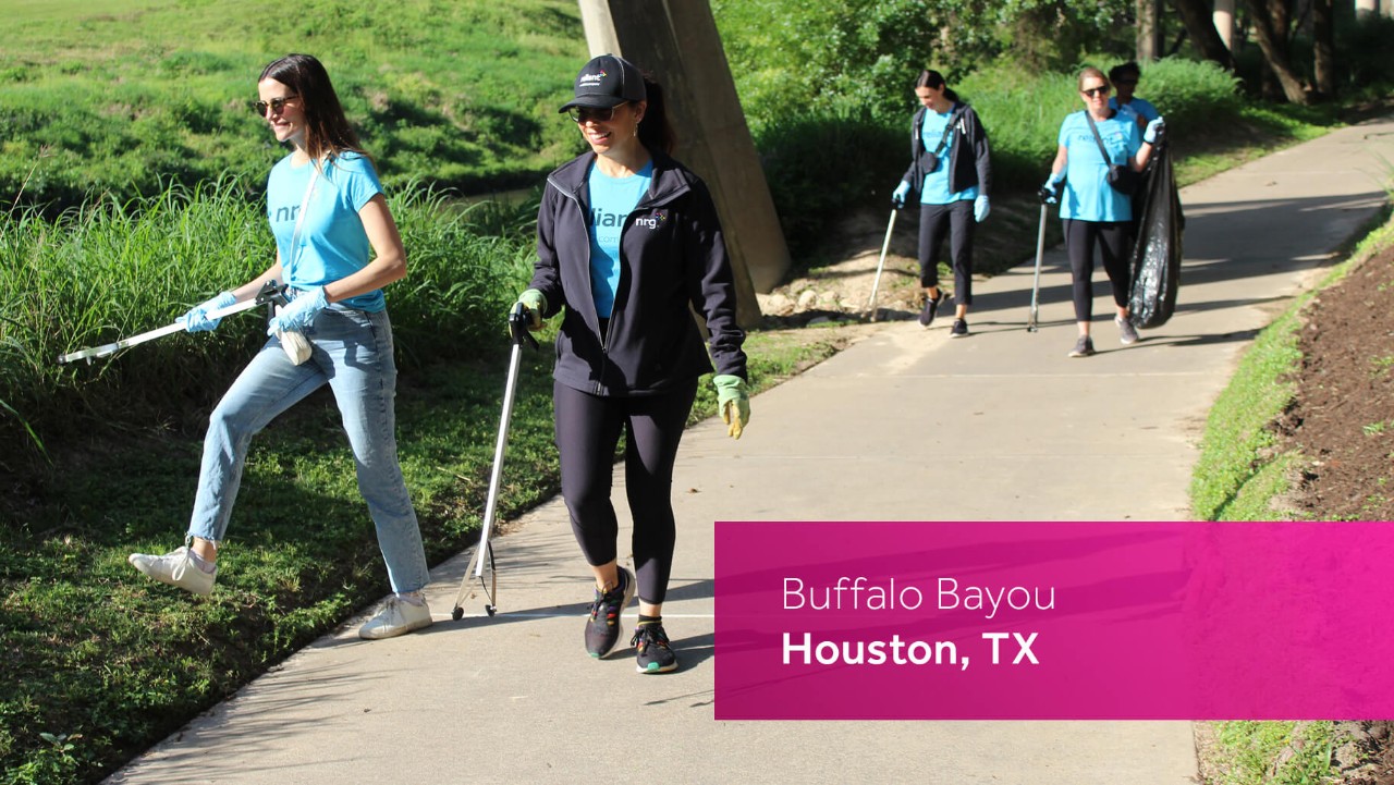 four people pick up litter along a sunny paved trail with trees and grass; sign says Buffalo Bayou, Houston, TX.